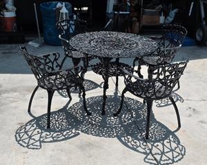 vintage cast iron patio set includes one table and four matching chairs. Color is Black With copper highlights