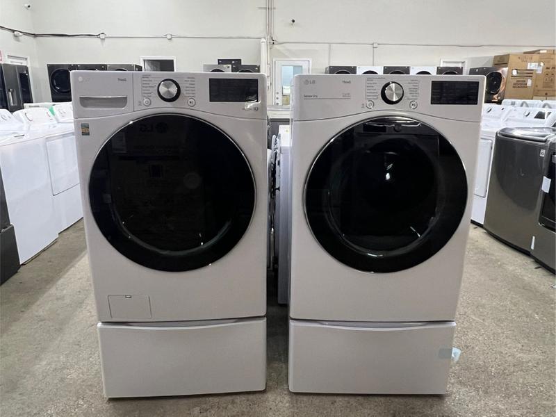 White front load washer and dryer set with pedestals for sale in